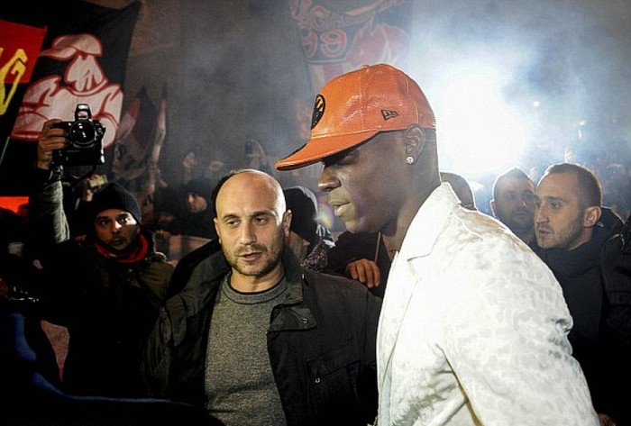 Balotelli, đội một chiếc mũ màu cam và được các vệ sĩ bao quanh, đặt chân tới nhà hàng Giannino để ăn tối với các quan chức của Milan.